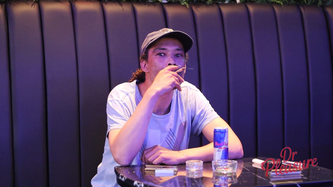 Een bezoeker geniet van een joint en een drankje